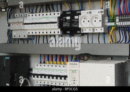 Electrical circuit breakers and plug points in an electrical switchboard. Add film grain effect Stock Photo