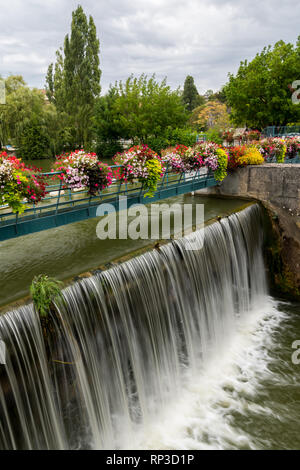 The weir of Kir lake, an artificial lake located south west of Dijon (Burgundy, France) with beautiful flowers on a cloudy day in summer Stock Photo
