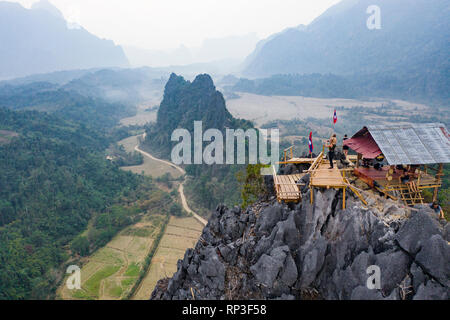 (View from above) Stunning aerial view of some tourists taking pictures at the beautiful panorama from the Nam Xay viewpoint in Vang Vieng, Laos. Stock Photo