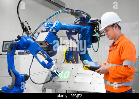 Engineer programming control laser robotic cutting on metal plate, Industry 4.0 concept Stock Photo