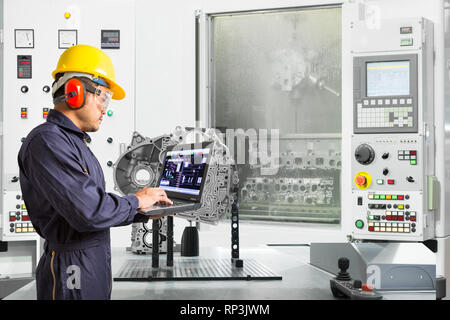 Engineer using laptop computer control automotive CNC machine in automotive industry, Smart factory concept Stock Photo