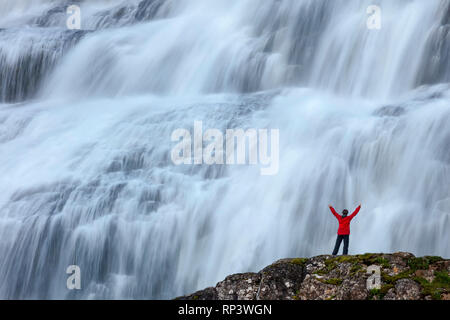 Person dwarfed by Dynjandi waterfall, or Fjallfoss, Westfjords, Iceland. Stock Photo
