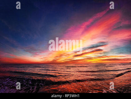 Awesome golden hour sunset over the beach with wonderful pastel colored sky Stock Photo