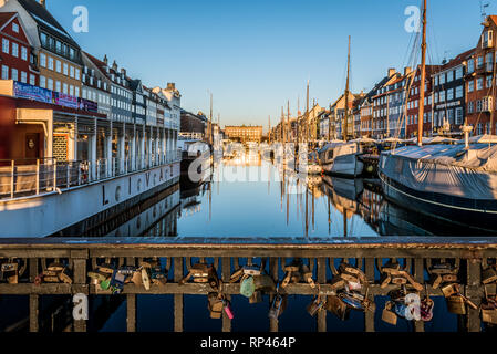 Padlocks fixed to the barrier on the bridge over Nyhavn Canal in Copenhagen in the first morning light, Copenhagen, February 16, 219 Stock Photo