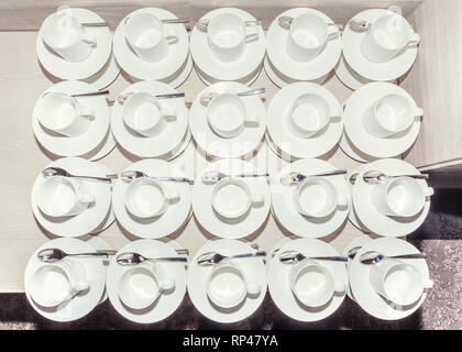 Set of Empty white ceramic tea or coffee cup and saucers, top view. Two cups missing spoons, not all equal, pattern, Stock Photo