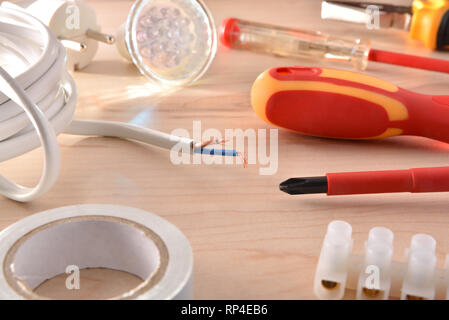 Composition of tools for electrical repairs on wooden table. Horizontal composition. Elevated view. Stock Photo