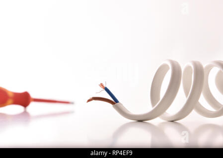 Electricity concept with coiled cable and screwdriver background. Front view. Horizontal composition. Stock Photo