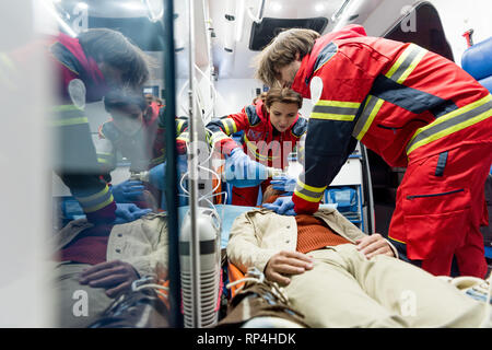 Paramedics doing cardiopulmonary resuscitation in ambulance car Stock Photo