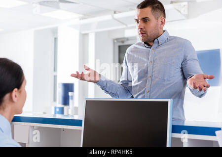 Surprised man talking to nurse in clinic Stock Photo