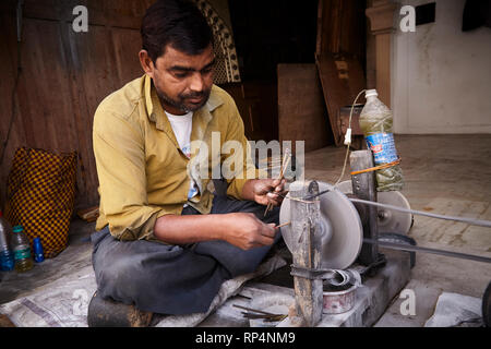 Craftsmen polishes precious stone in a small factory. Stock Photo