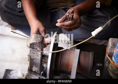 Craftsmen polishes precious stone in a small factory. Stock Photo