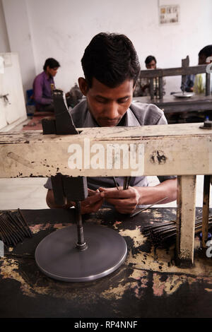 Craftsmen polishes precious stone in a small factory. Stock Photo