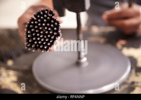 Craftsmen polishes precious stone in a small factory. Stock Photo