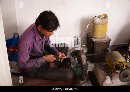 Craftsmen polishes precious stone in a small factory. Stock Photo