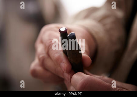 Craftsmen polishes precious stone in a small factory. Stock Photo