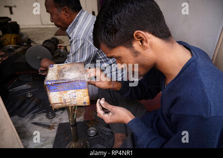 Craftsmen polishes precious stone in a small factory. Stock Photo