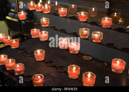 Lit votive candles inside a church Stock Photo