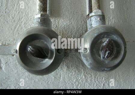 Old electrical switch. Vintage industrial switch on the wall. Stock Photo