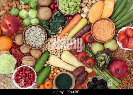 Health food for a high fibre diet concept with fruit, vegetables, whole grain bread, grains, legumes, nuts, grains, seeds, spirulina and cereals. Stock Photo