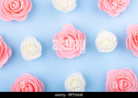white and pink decorative roses on blue paper, colorful flower background Stock Photo