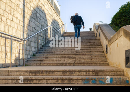 Valencia,Spain - February 16, 2019:  Man climbing up the stairs. Getting up. Stock Photo