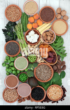 High protein super food with fresh vegetables, tofu, dried fruit, legumes, nuts, supplement powders, grains and seeds. Stock Photo