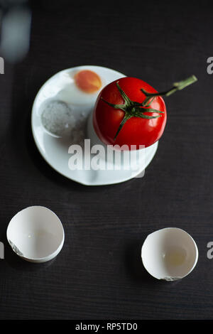 a bright red tomato on a branch hatched from an egg Stock Photo