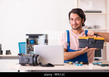 Young male contractor repairing computer Stock Photo