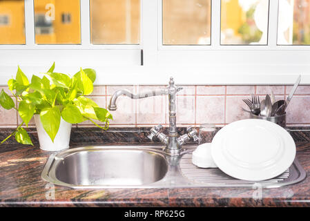 The Clean dishes are drying, on rustic kitchen metal sink Stock Photo - Alamy