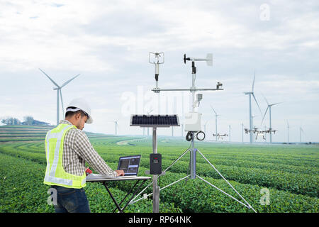 Engineer using tablet computer collect data with meteorological instrument to measure the wind speed, temperature and humidity and solar cell system o Stock Photo