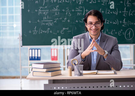 Young handsome math teacher in classroom Stock Photo