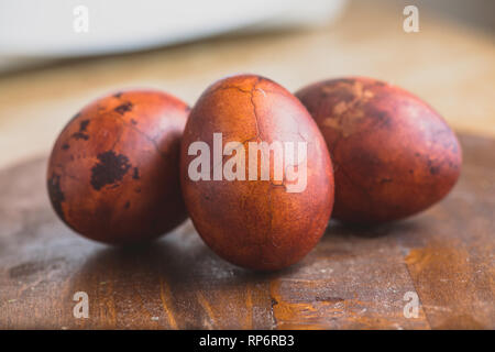 Easter eggs on wooden background. Painted brown with spots and cracks. Selective focus macro shot with shallow DOF Stock Photo
