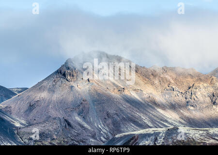 Landscape closeup view of Laugarvatn mountains with clouds covering on golden circle in Iceland during day and blue color sky in autumn Stock Photo