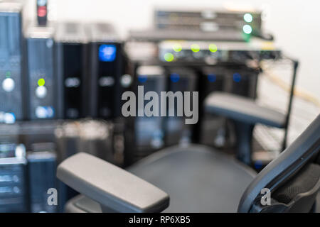 Office room in closeup of black chair and bokeh background of computer electronics server and lights at workplace Stock Photo