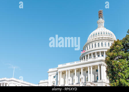 Washington DC, USA US Congress dome construction exterior with steps stairs view and flag on Capital capitol hill with blue sky columns pillars and sc Stock Photo