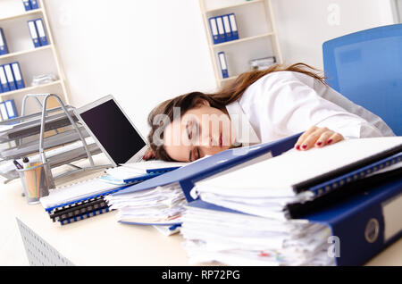 Young female employee unhappy with excessive work Stock Photo