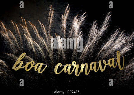Boa Carnaval, Portuguese for Happy Carnival message in elegant shiny gold script strung in front of shimmering bursts of fireworks in Rio de Janeiro Stock Photo