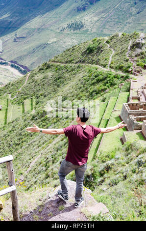 Tourist exploring the Inca Trails leading to the ruins of Pisac, Sacred Valley, major travel destination in Cusco region, Peru. Vacations and adventures in South America. Stock Photo