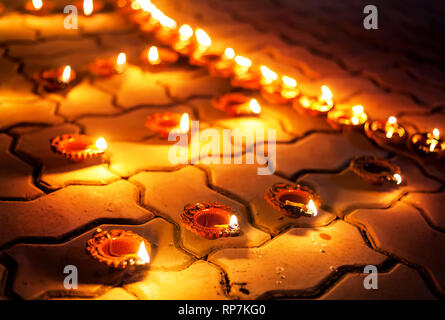 Traditional clay diya lamps lit on the ground during festival diwali celebration Stock Photo