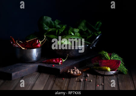 Red chili pepper beetroot and spinach leaves on the table at dark background Stock Photo