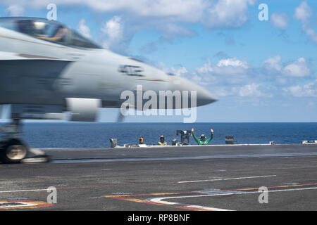 190218-N-HX510-2017 PACIFIC OCEAN (Feb. 18, 2019) Sailors observe an F/A-18E Super Hornet assigned to Strike Fighter Squadron (VFA) 151 launch from the flight deck of the aircraft carrier USS John C. Stennis (CVN 74) in the Pacific Ocean, Feb. 18, 2019. John C. Stennis is deployed to the U.S. 7th Fleet area of operations in support of security and stability in the Indo-Pacific region. (U.S. Navy photo by Mass Communication Specialist Seaman Jarrod A. Schad/Released) Stock Photo