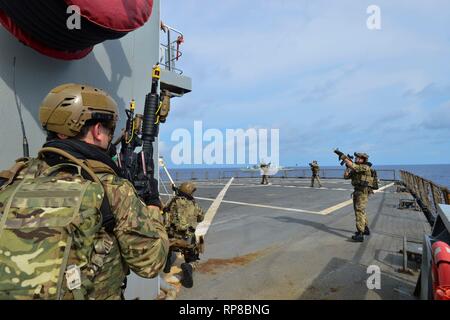 190218-N-NI298-129 GULF OF THAILAND (Feb. 18, 2019) - Royal Marine commandos and Royal Navy sailors attached to the Duke-class frigate HMS Montrose (F 236) conduct a visit, board, search and seizure drill aboard the Henry J. Kaiser-class fleet replenishment oiler USNS Guadalupe (T-AO 200).  During the drill, commandos and sailors coordinated with Guadalupe crew members to simulate maritime interdiction operations and execute proper VBSS procedures. Guadalupe is conducting operations which provides logistical support to U.S. Navy and allied forces operating in the U.S. 7th Fleet area of respons Stock Photo