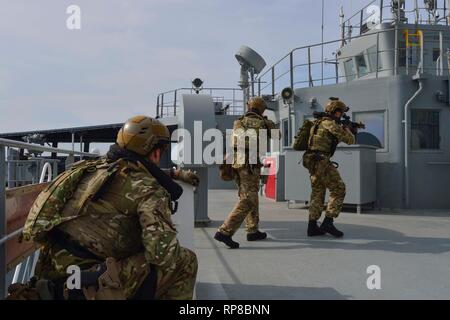 190218-N-NI298-160 GULF OF THAILAND (Feb. 18, 2019) - Royal Marine commandos and Royal Navy sailors attached to the Duke-class frigate HMS Montrose (F 236) conduct a visit, board, search and seizure drill aboard the Henry J. Kaiser-class fleet replenishment oiler USNS Guadalupe (T-AO 200).  During the drill, commandos and sailors coordinated with Guadalupe crew members to simulate maritime interdiction operations and execute proper VBSS procedures. Guadalupe is conducting operations which provides logistical support to U.S. Navy and allied forces operating in the U.S. 7th Fleet area of respons Stock Photo