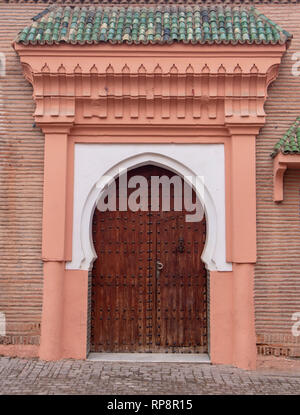 Traditional Moroccan style design of an ancient wooden entry riad door. In the old Marrakech, Morocco. Typical, old, brown intricately carved, studded Stock Photo