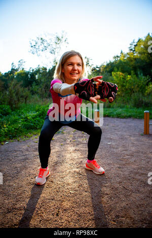 Photo of young girl stretching in summer park Stock Photo