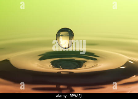 Drop falling on smooth surface of water Stock Photo