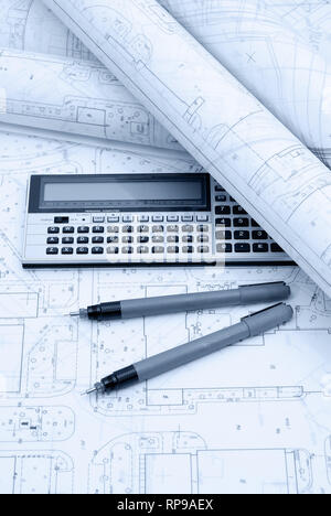 Architectural plans, calculator and drawing utensil. Picture in blue ...