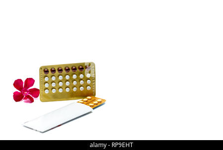 Contraceptive pills or birth control pills with pink flower on white background with copy space. Hormone for contraception. Family planning concept. W Stock Photo