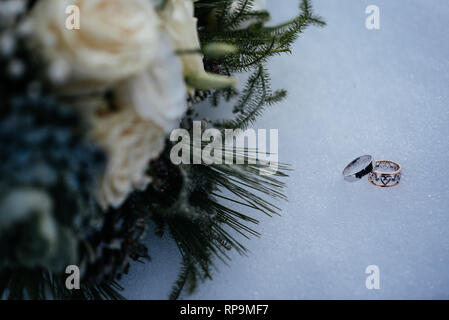Wedding bouquet and rings on snow Stock Photo