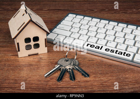 wooden miniature house with door keys and a pc keyboard close up Stock Photo